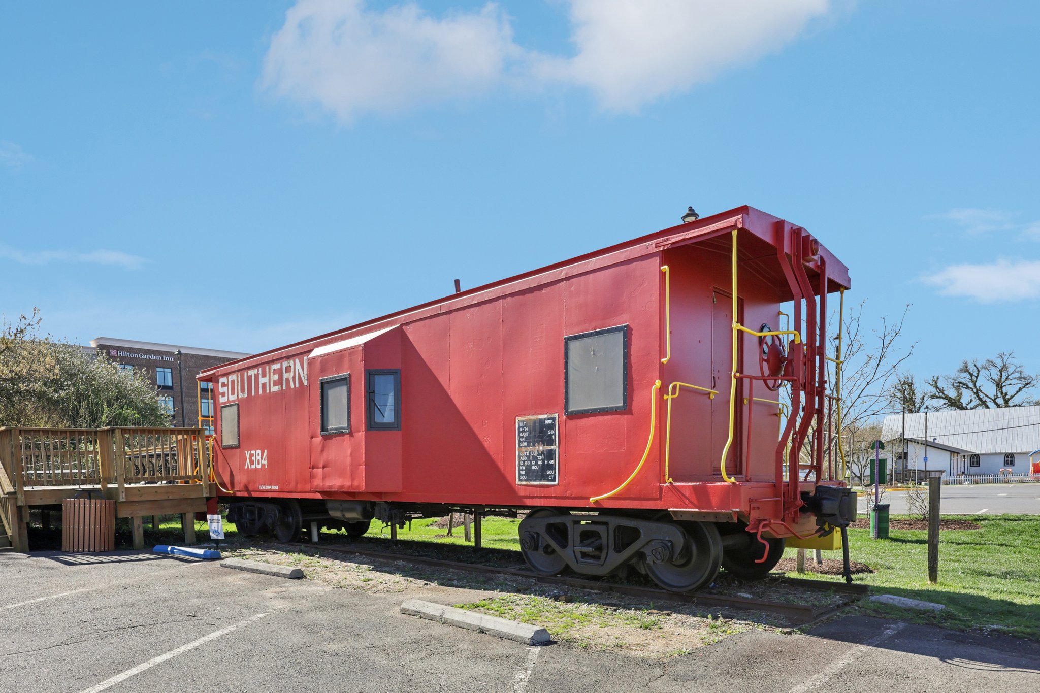 A street view image of a historical red train on display in Haymarket, Virginia.