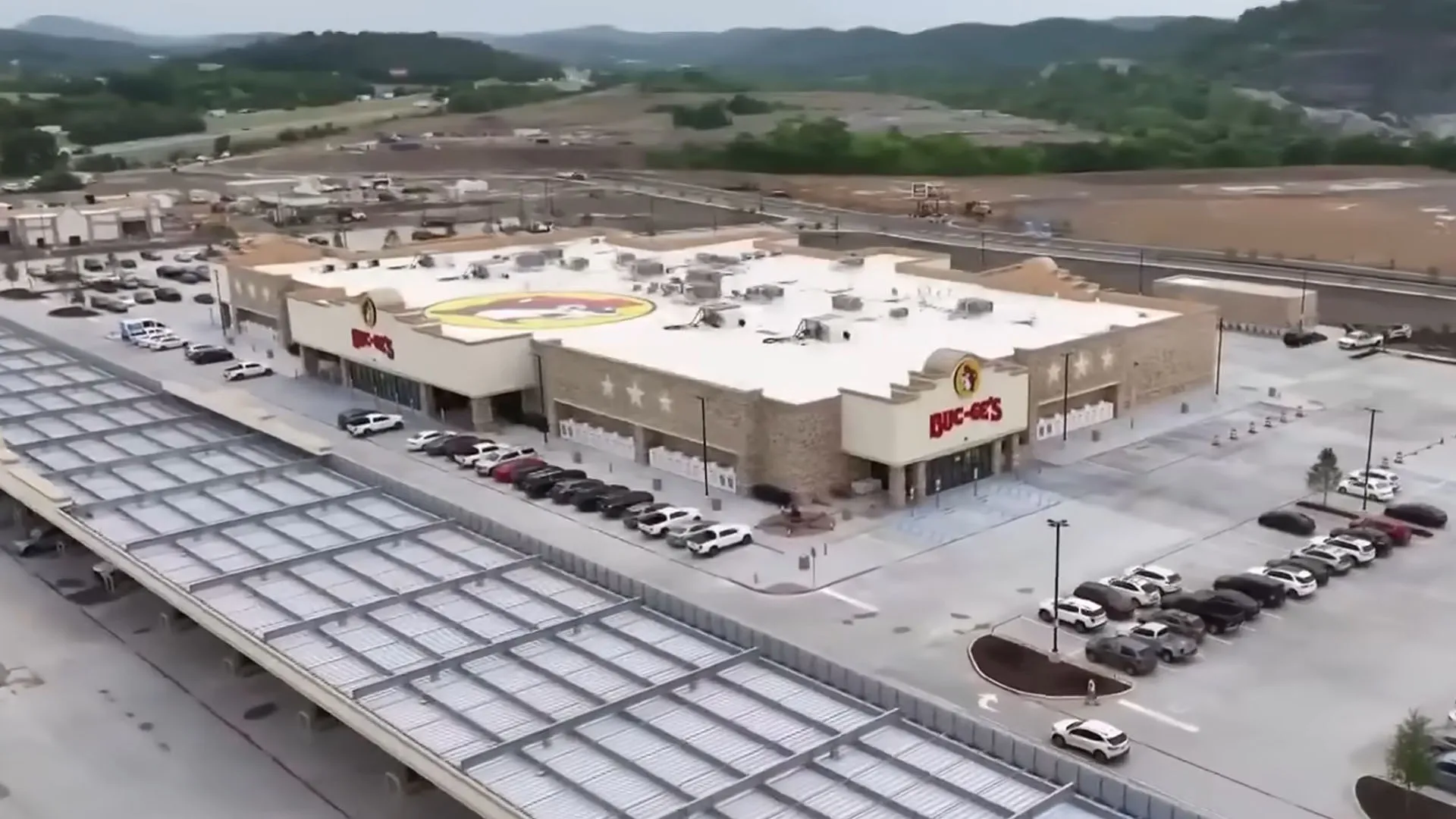Aerial view of a large Buc-ee's travel center, showing the massive building and long rows of covered gas pumps, similar to the 74,000 sq ft model proposed for Stafford, VA.