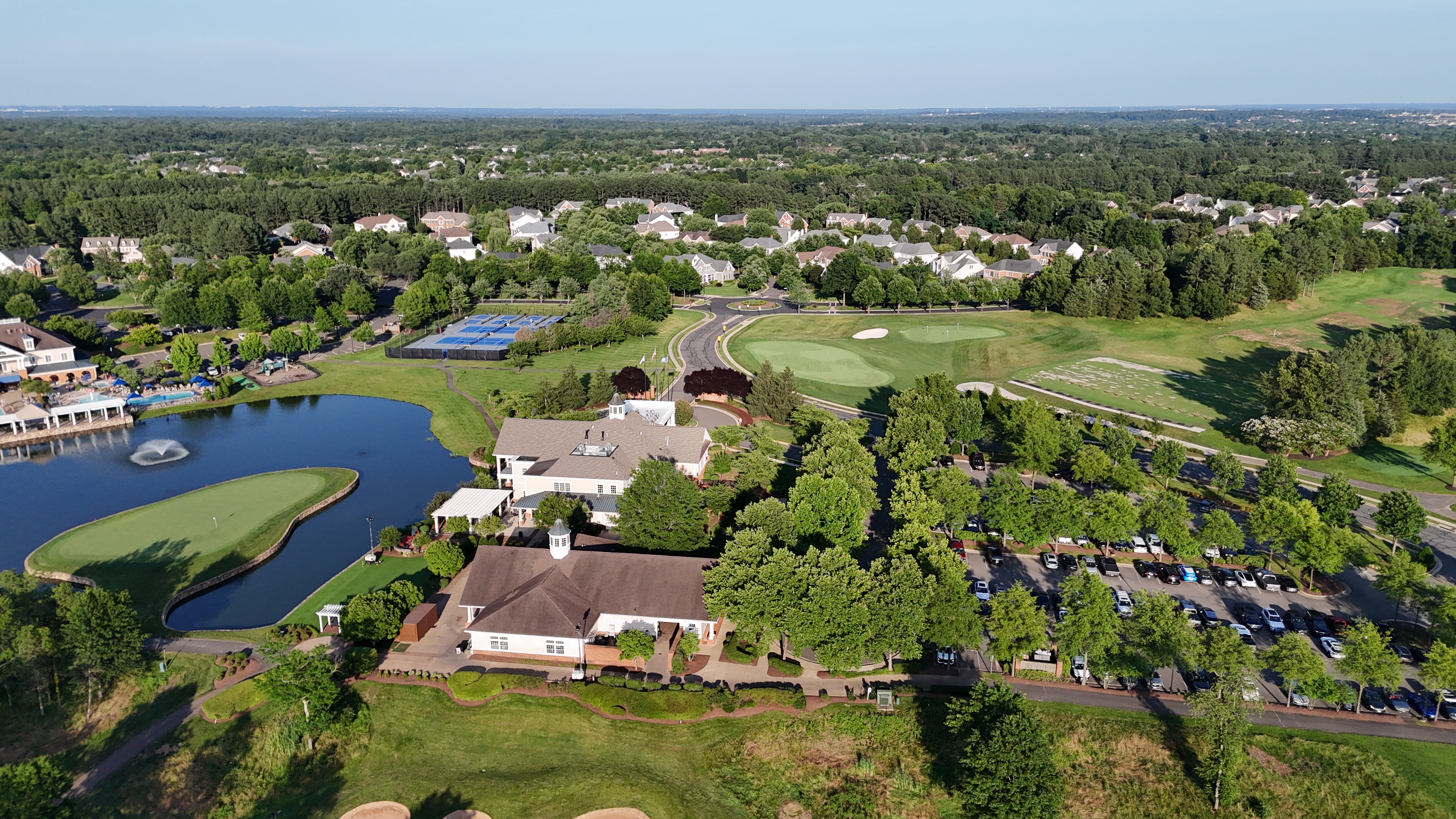 An aerial drone shot of a lush green fairway and several large sand traps on the Dominion Valley Country Club golf course.