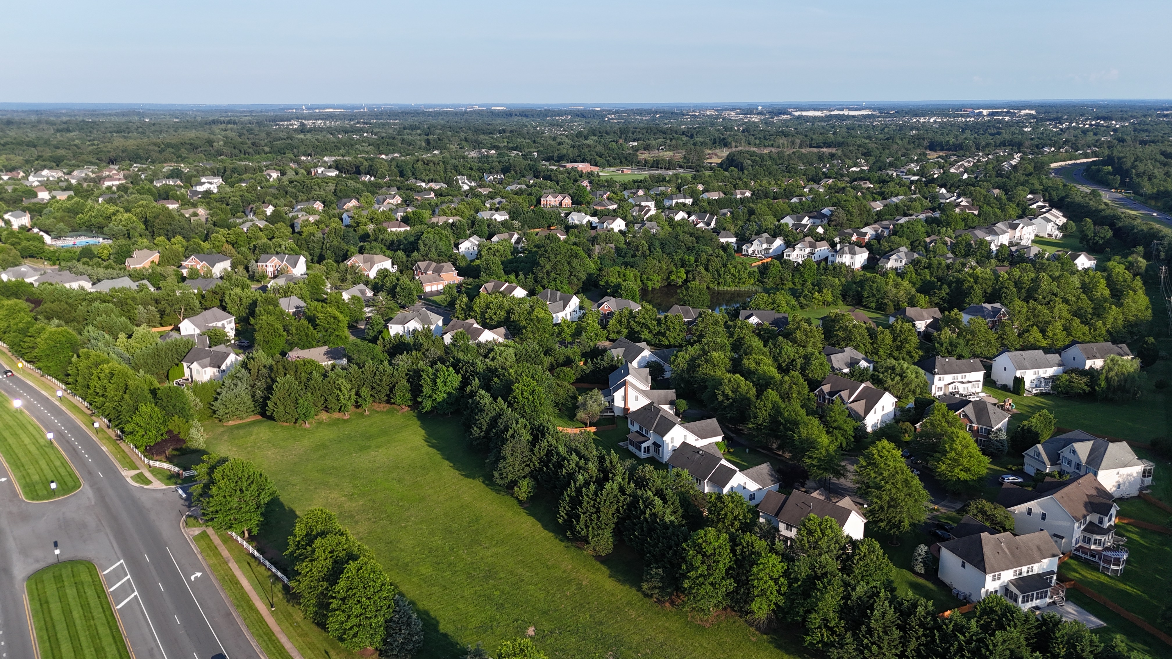 A sprawling aerial view of the homes in the Dominion Valley neighborhood of Haymarket, Virginia, surrounded by mature trees.