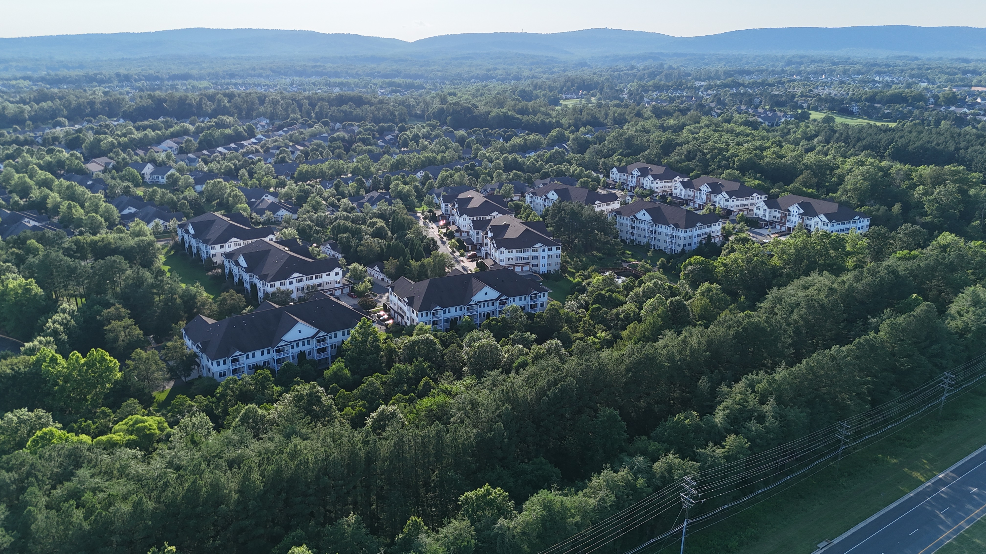 An aerial view of the townhome-style condominiums in Dominion Valley, Haymarket, with the Bull Run Mountains visible in the background.